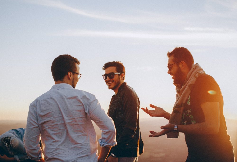 three men standing while laughing
