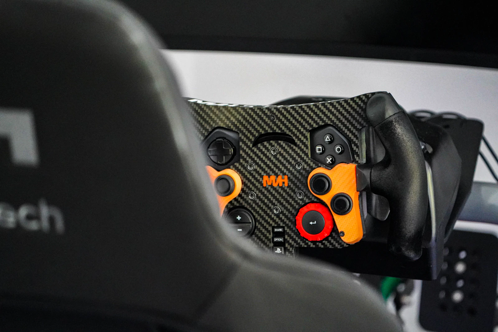 Puesto de simulación de conducción con monitor mostrando un juego de carreras